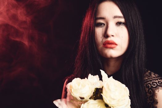

A Woman Crying while Holding White Roses