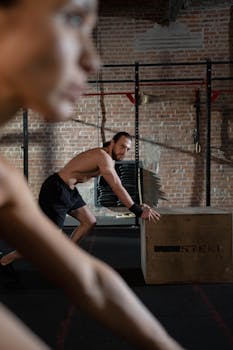 Man engaging in a rigorous indoor workout featuring plyometric training with a wooden box.
