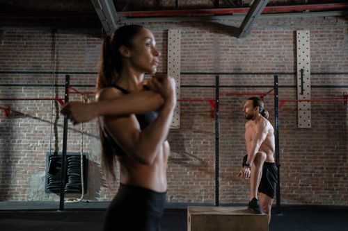 Free Two athletes warming up in an industrial-style gym, preparing for an intense workout session. Stock Photo