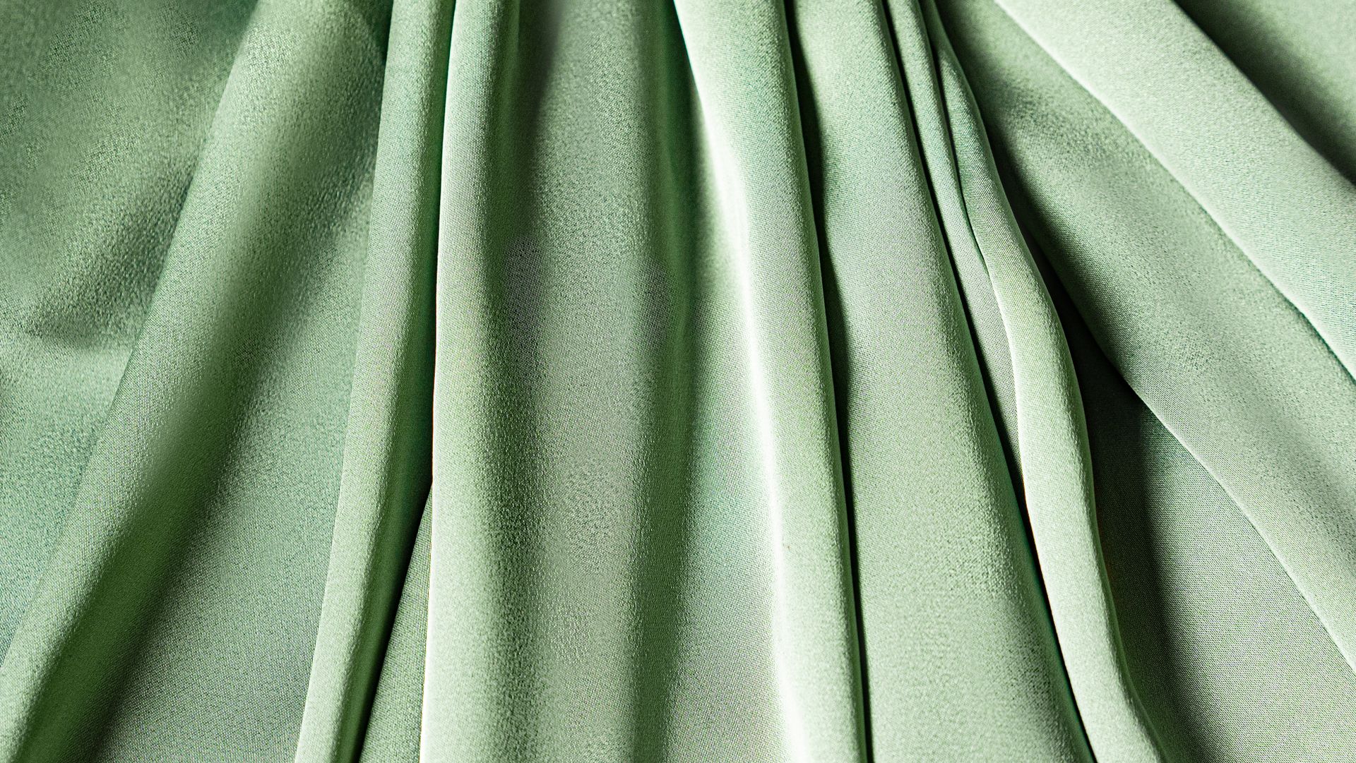Close-up of green fabric with a textured and pleated design, ideal for fashion or design concepts.