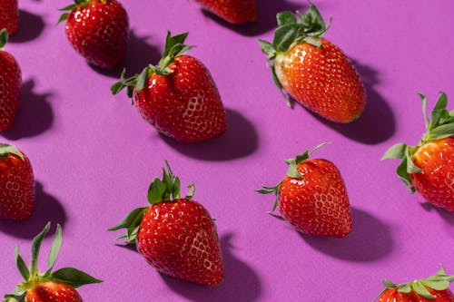 

A Close-Up Shot of Strawberries on a Purple Surface