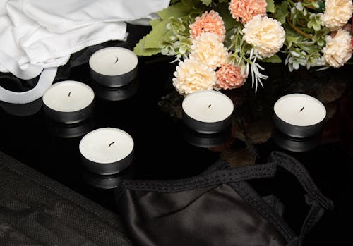 
A Close-Up Shot of Candles beside Flowers