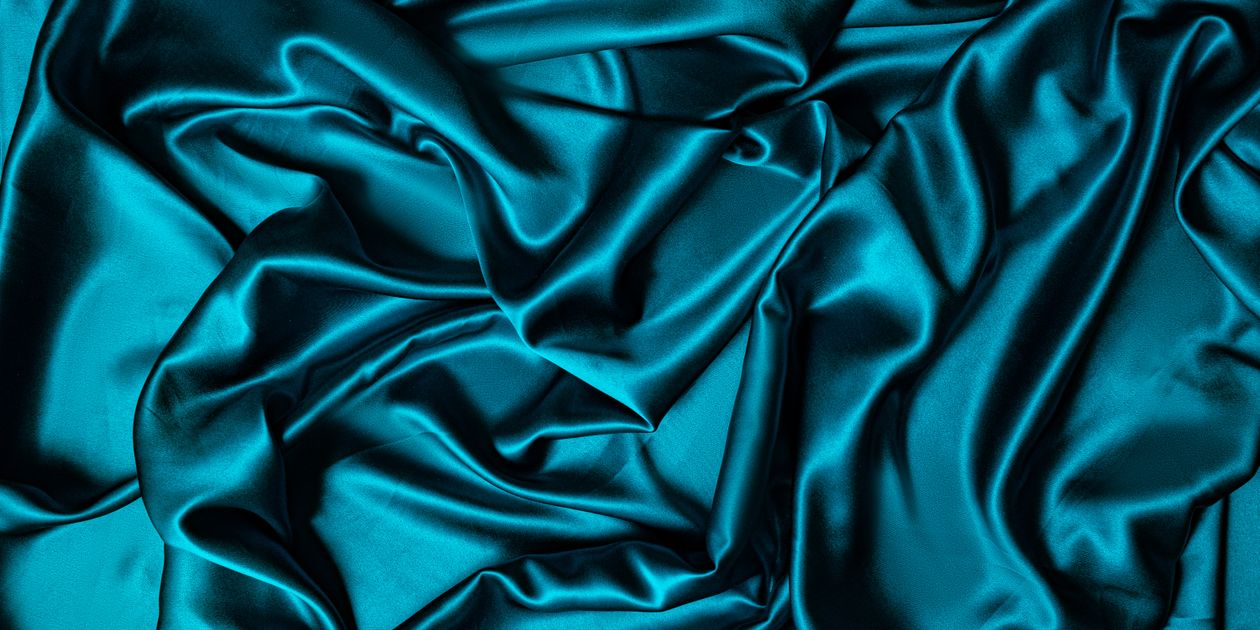 Satin xanh ngọc xếp nếp cho thấy ánh sáng phản chiếu trên bề mặt