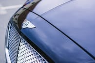 抛光豪华汽车引擎盖的详细视图，带有徽标和镀铬格栅