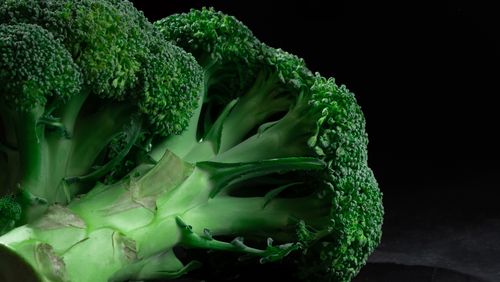 Fresh broccoli on a dark surface — photo by Mikhail Nilov on Pexels