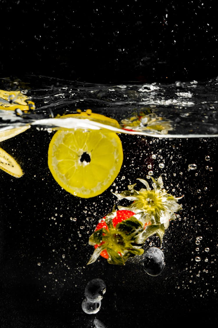 Sliced Lemon On Water With White Flowers