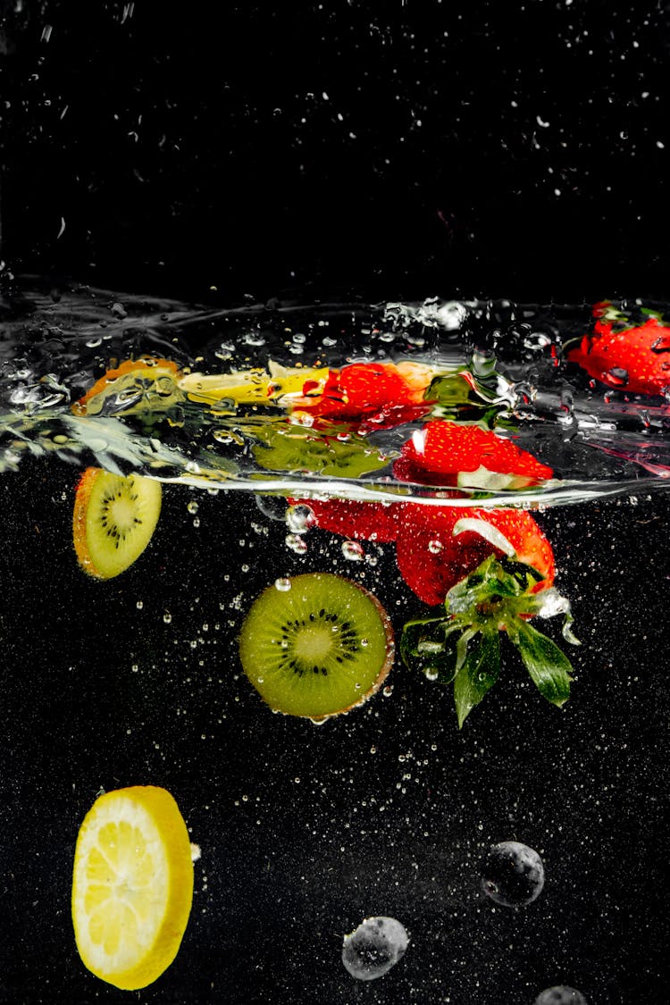 Strawberries, Kiwis And Lemon Slices Falling Under Clear Water 