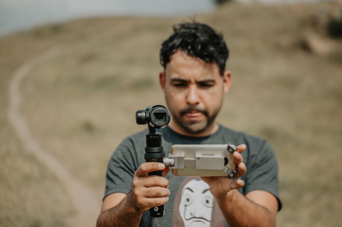 Mann filmt mit Smartphone auf einem Gimbal – Reels und Shorts ohne Filmteam.