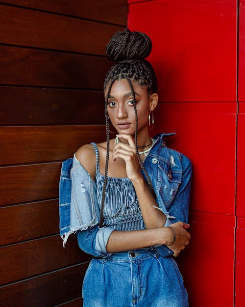 A Braided Hair Woman in Denim Clothes with Her Hand on Her Chin