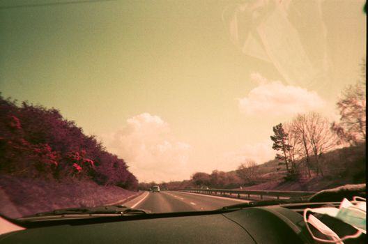 View from car driving on a scenic rural highway under a clear sky.