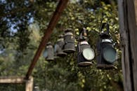 绿叶掩映下，户外悬挂着古色古香的黑色灯笼