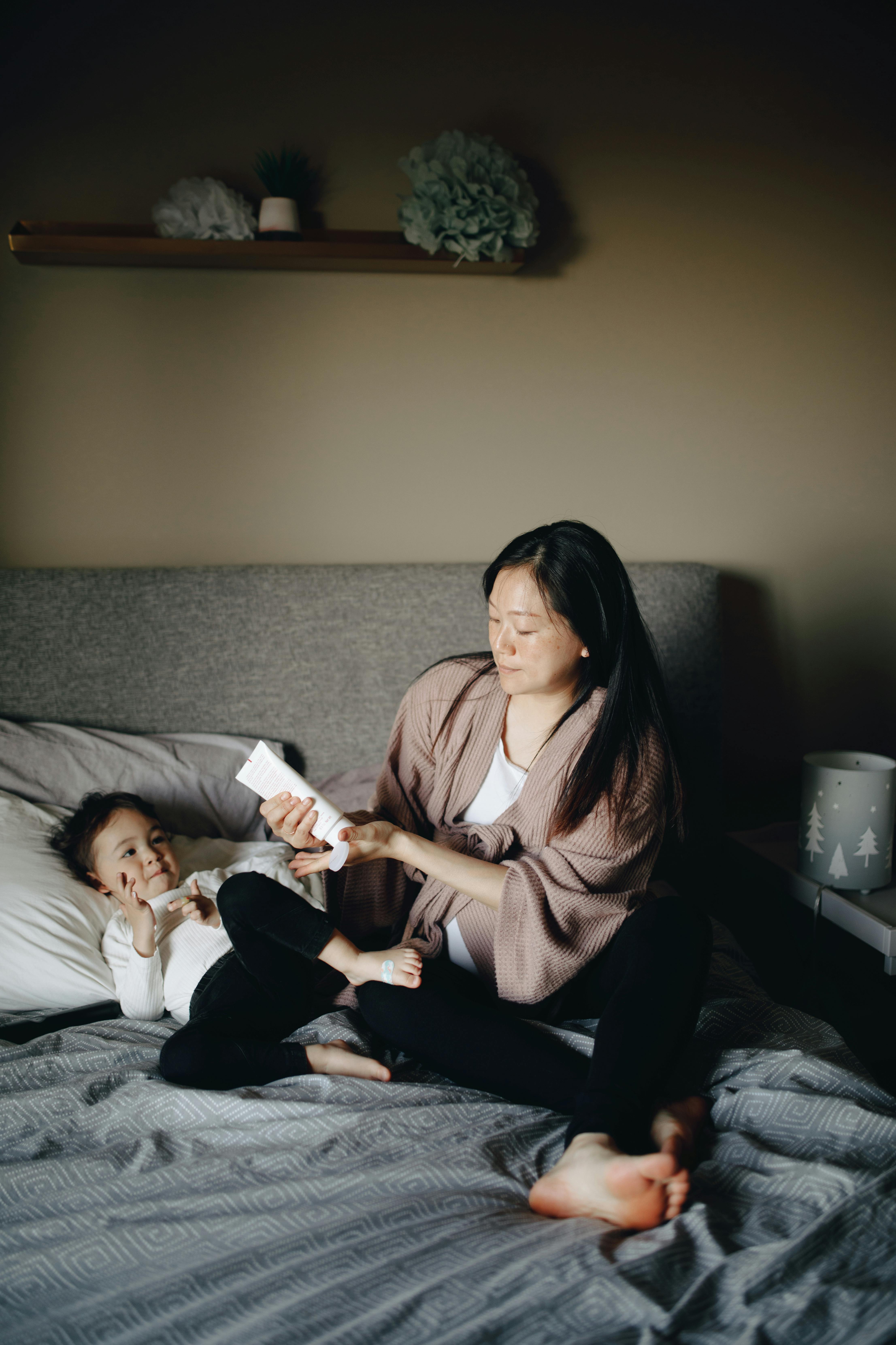 a mother applying lotion on her child