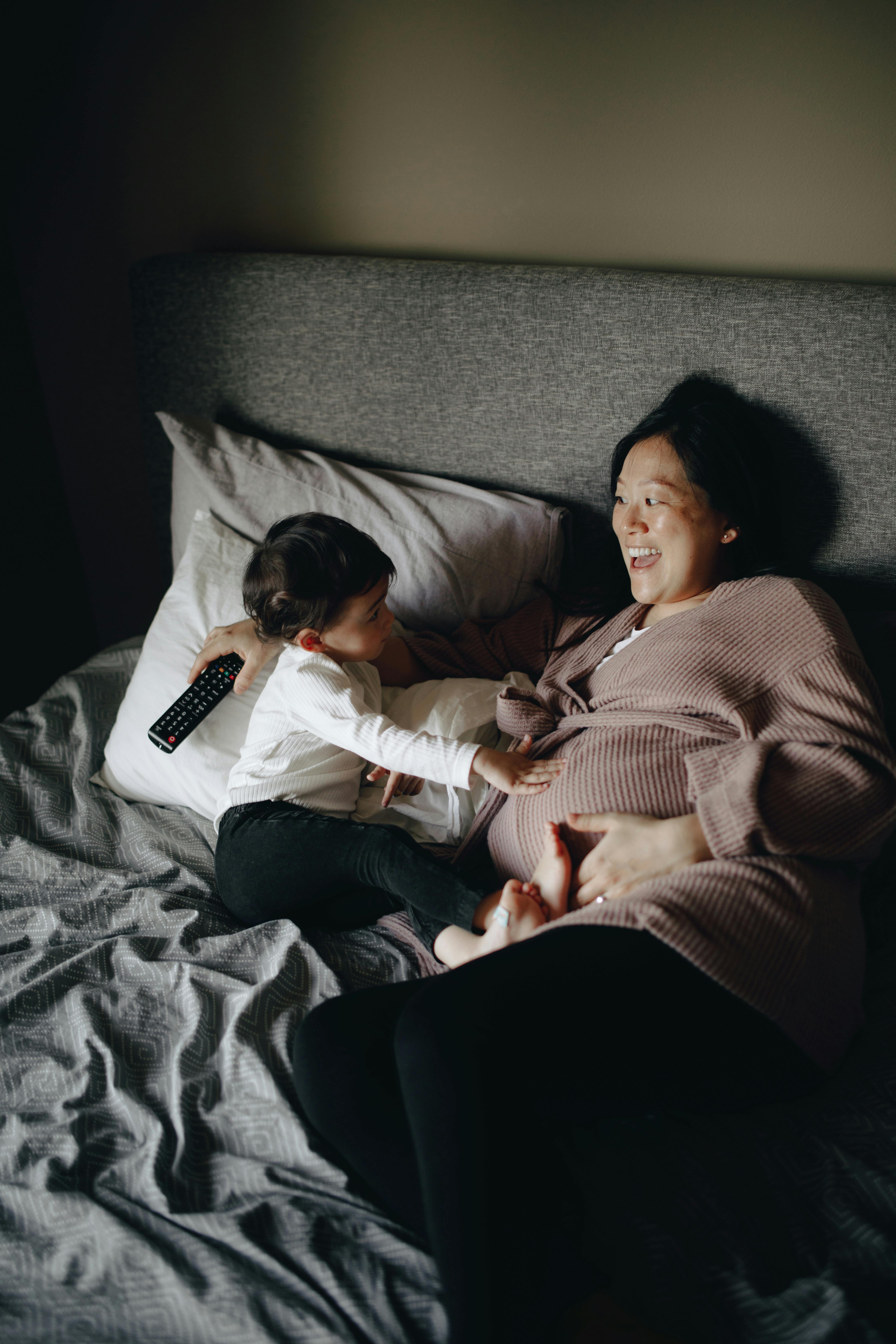 pregnant mother and baby lying down on bed