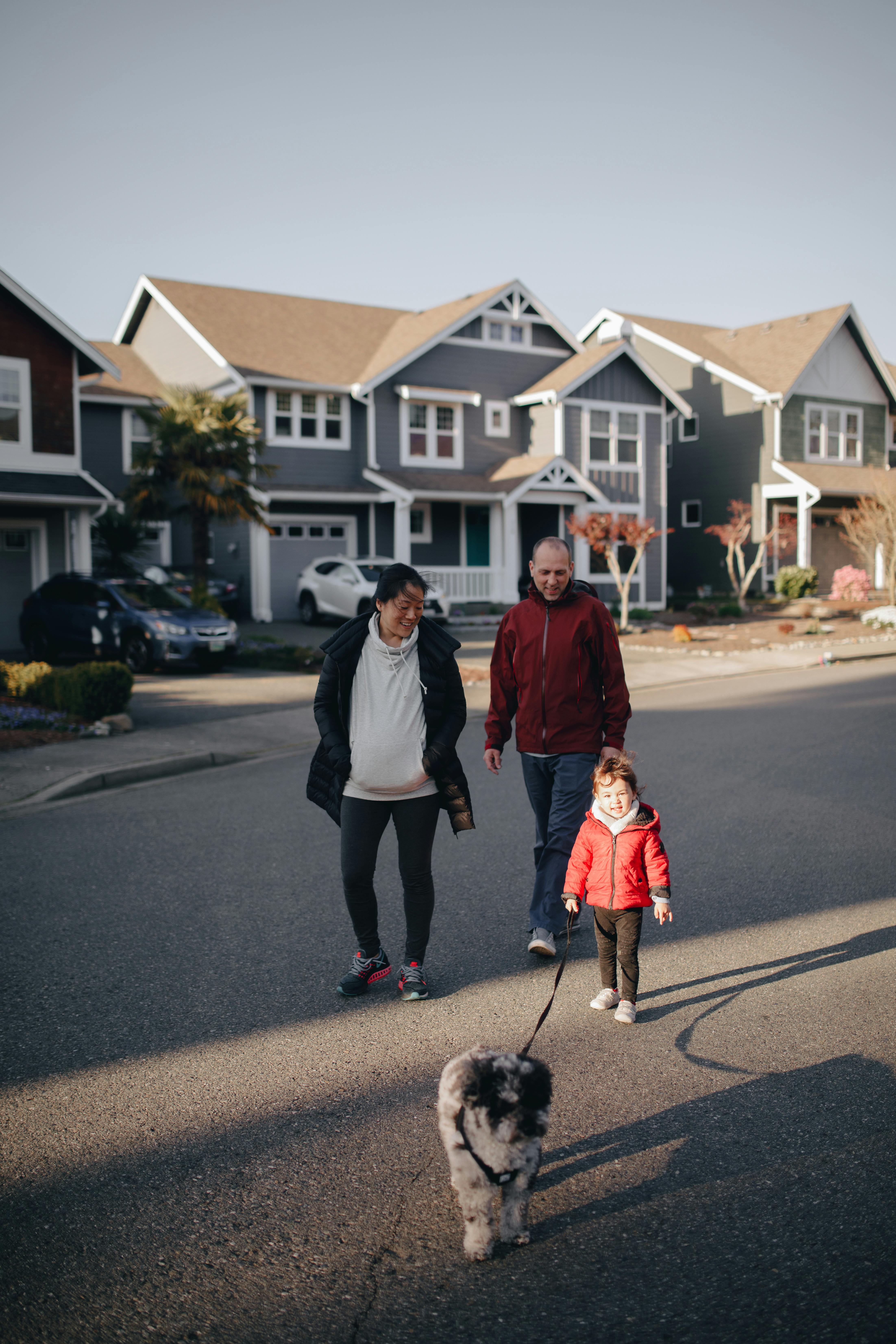 a child walking the dog with her parents