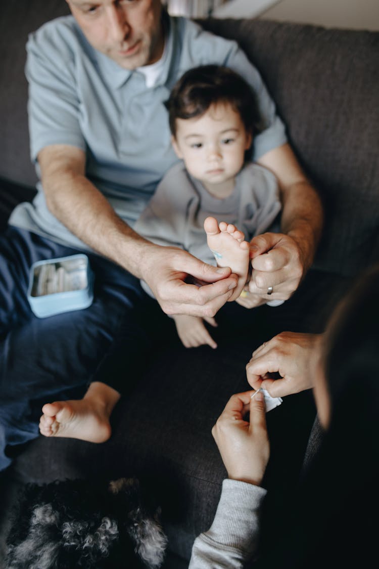 Couple Putting Band Aid On Their Child's Foot