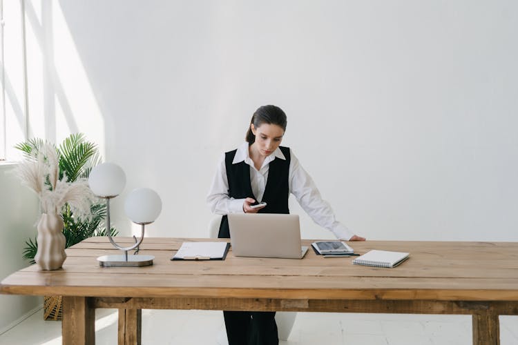 A Woman In A Vest Working In An Office