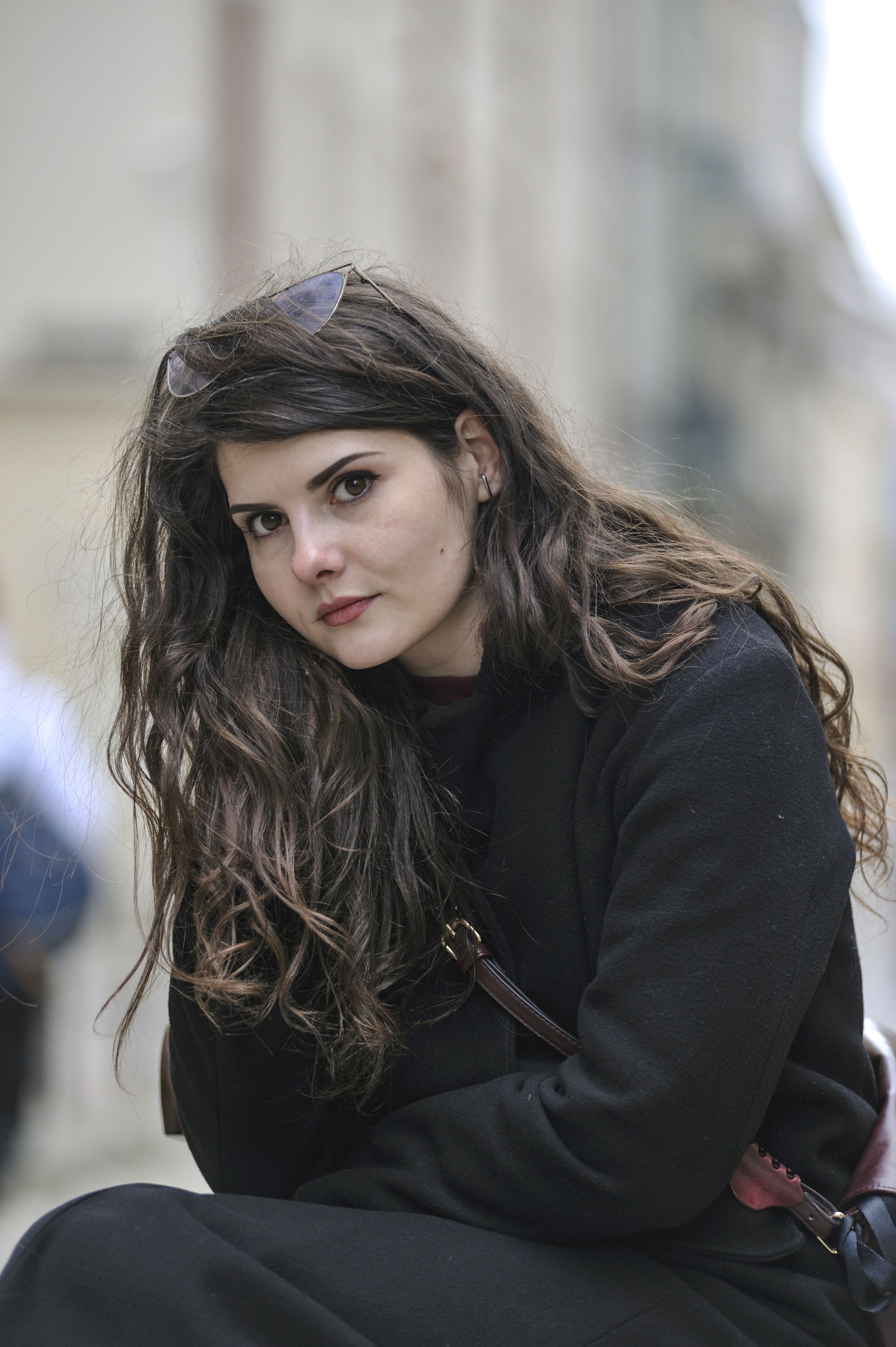 Elegant woman with long hair posing in a cityscape of Lviv, Ukraine.