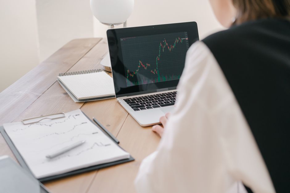 Business professional analyzing stock market trends on a laptop