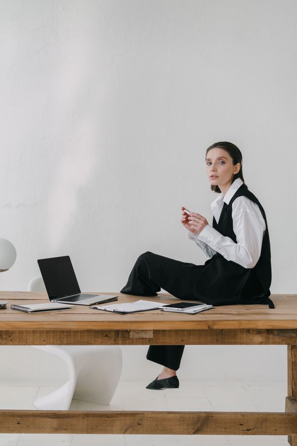 Woman in a white shirt and pleated trousers in minimalist office style