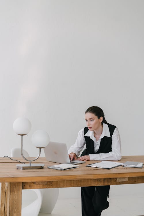 A  Woman in Business Attire Working with a Laptop