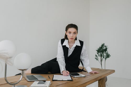 Free 
A Woman Taking Notes while Sitting on a Wooden Table Stock Photo