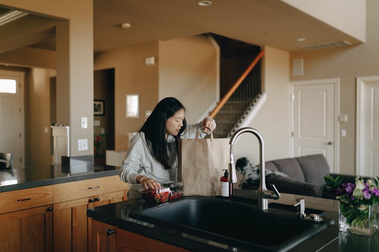 Woman Taking Out The Groceries From Paper Bag