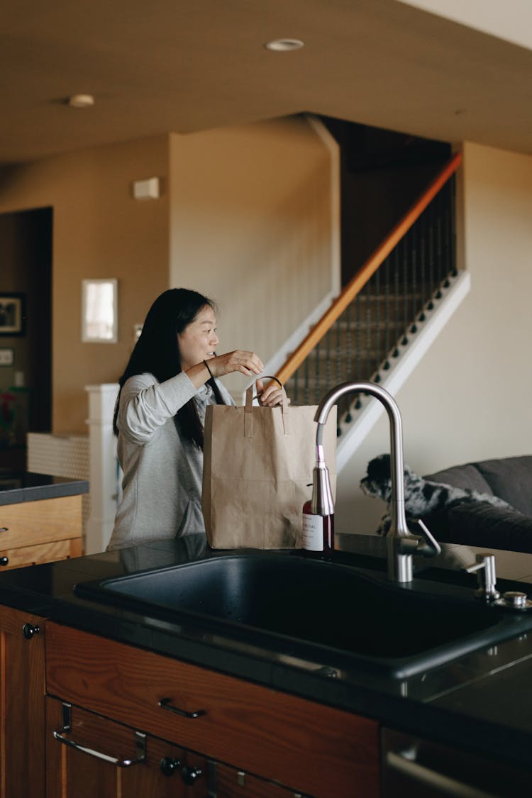 A Mother Bringing A Paper Bag Of Groceries