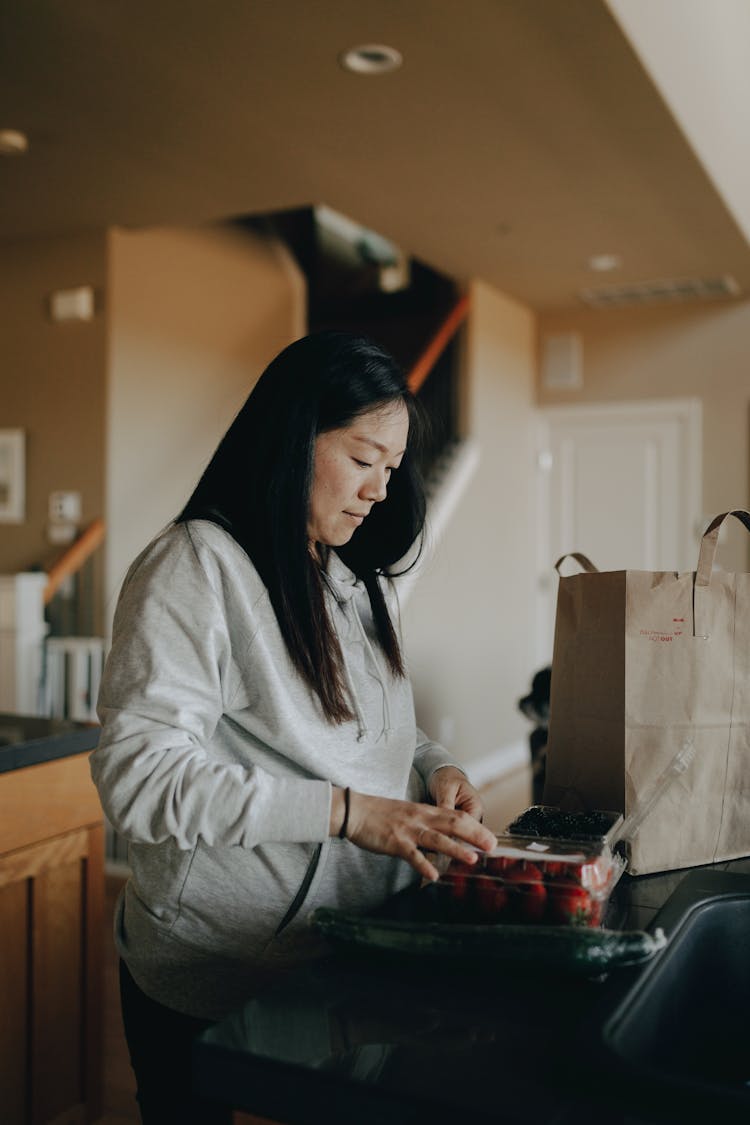 A Mother Putting Out Groceries From A Paper Bag