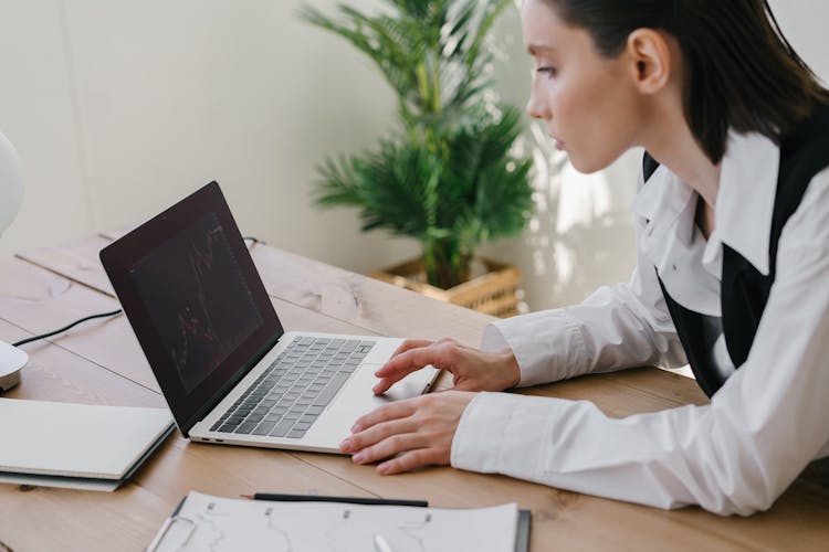 A Woman Looking At A Chart On The Laptop Screen