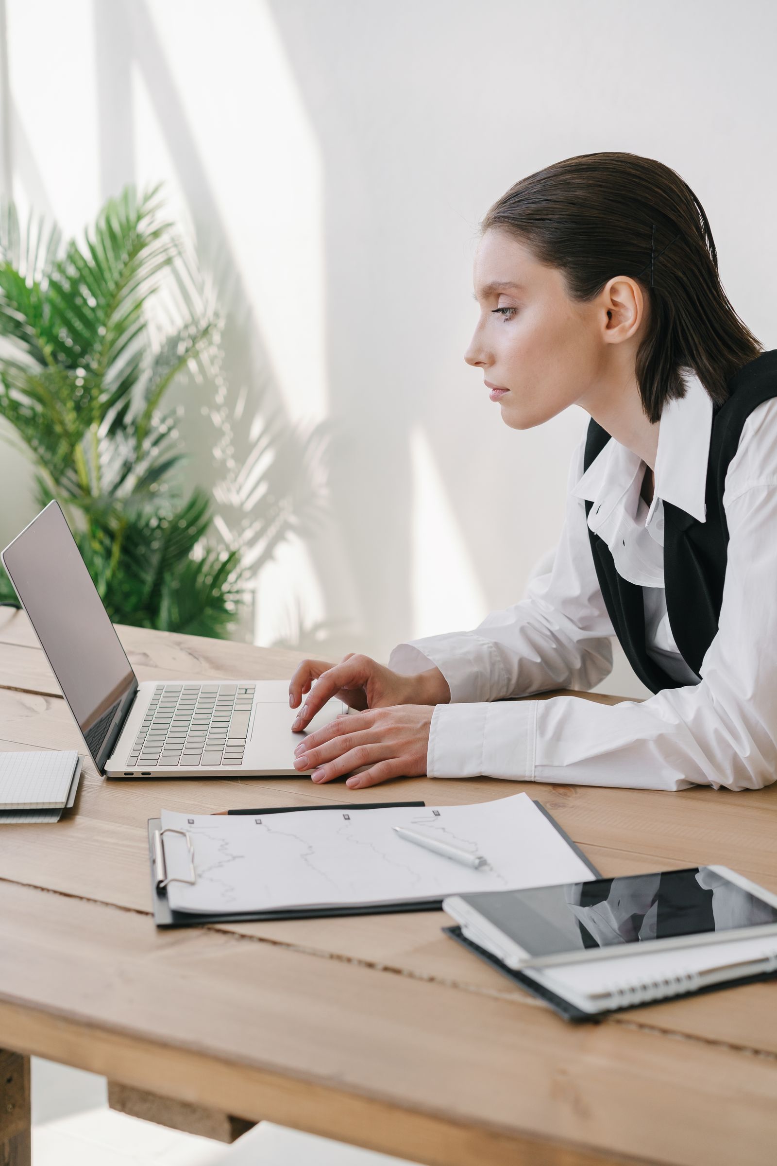 A person reviewing financial charts on a laptop alongside handwritten notes, representing the choice between automated and human retirement planning.