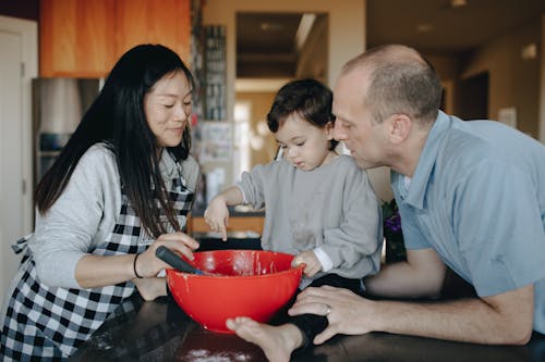 A Couple Baking With Their Child