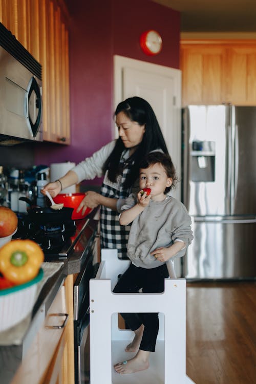 Woman Cooking With Her Little Girl Beside Her