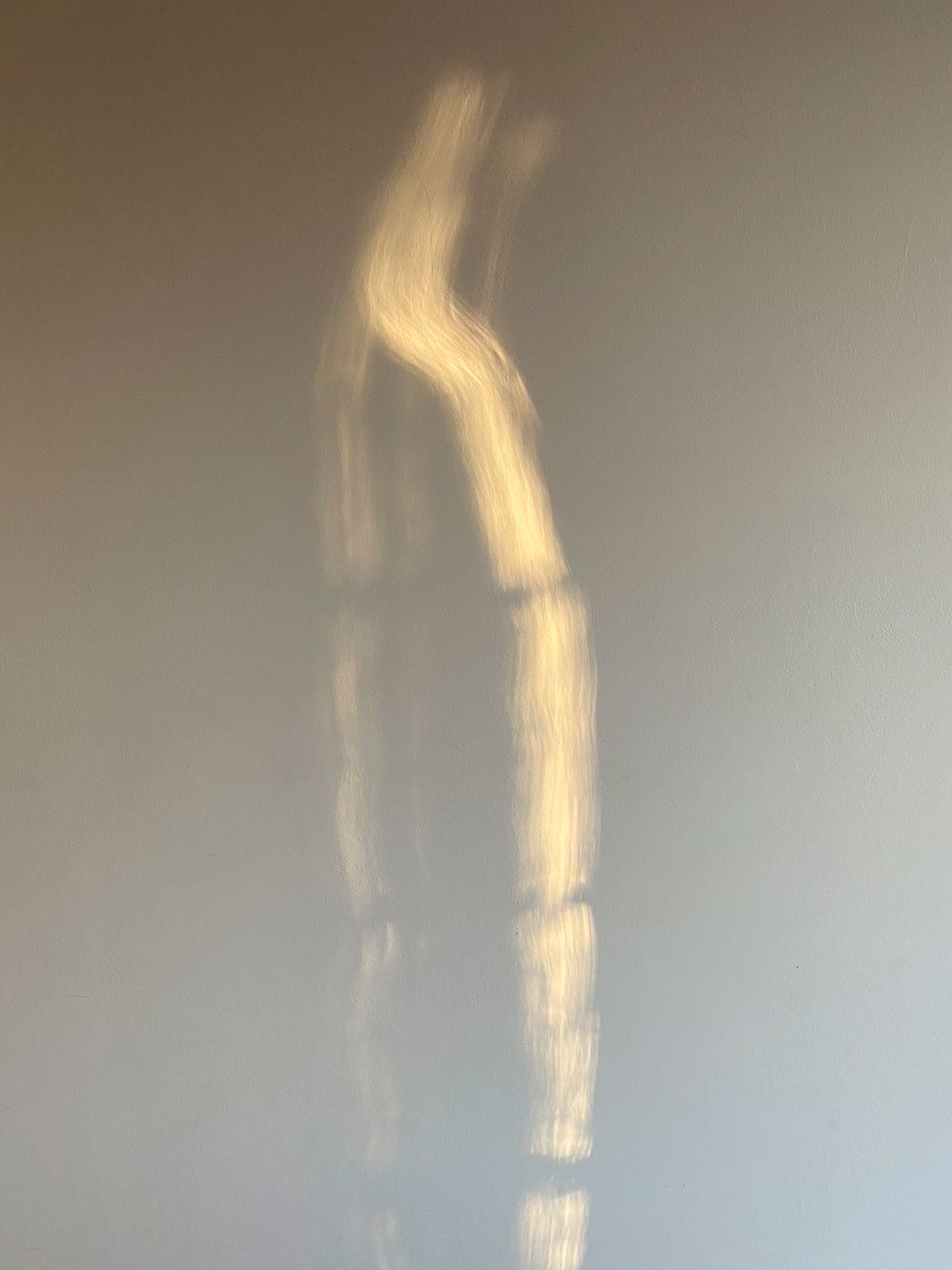 Lumière rasante sur un mur clair Tache de lumière projetée sur un mur blanc nu, sans mobilier ni objet.