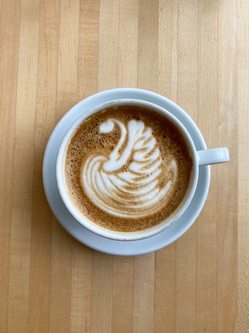 Cup of foamy cappuccino served on table in cafe