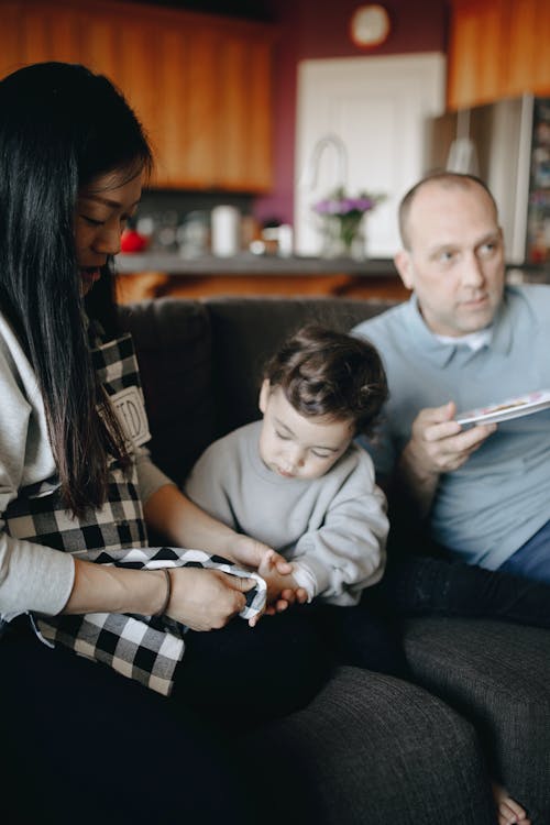 Family Sitting On A Sofa Spending Leisure Time Together