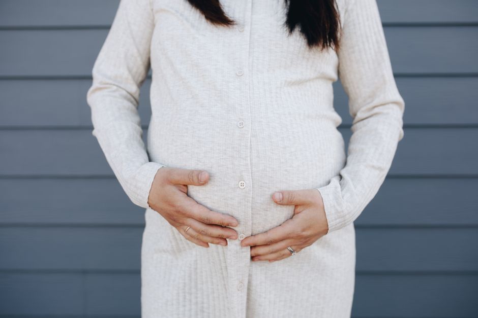 Round Ligament Pain and Urination: A Guide for Expecting Mothers pregnant woman holding belly - round ligament pain while peeing