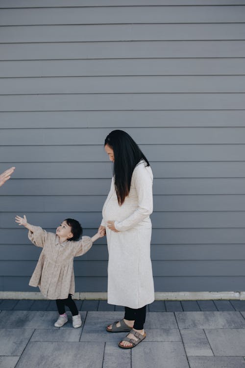 Free Mother And Child Standing Beside A Gray Wall Stock Photo