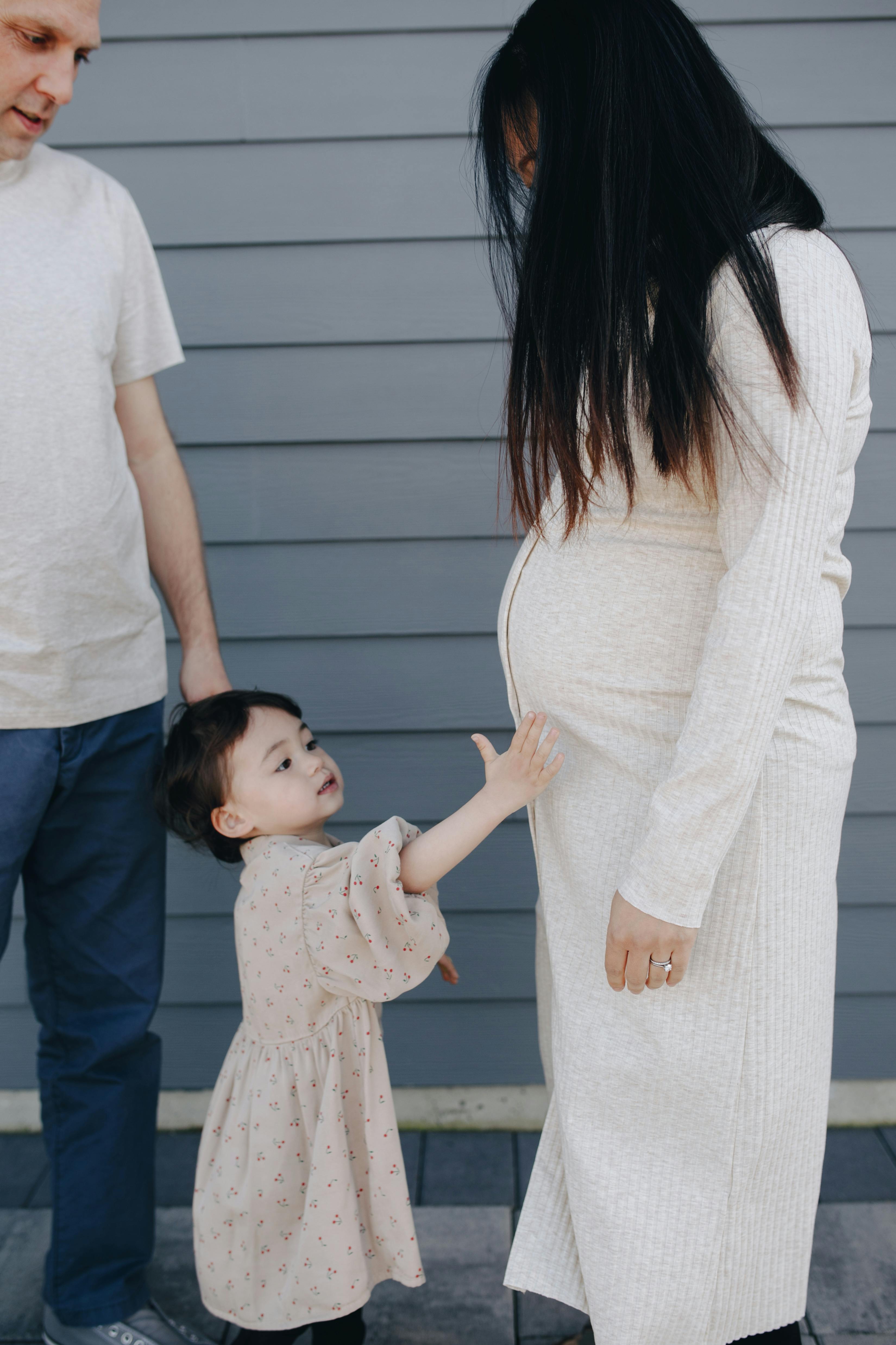 little girl holding her mom s tummy