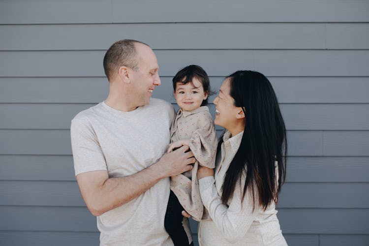 Couple Carrying Their Baby Girl