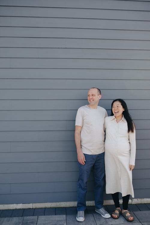 Couple Standing Near A Gray Wall