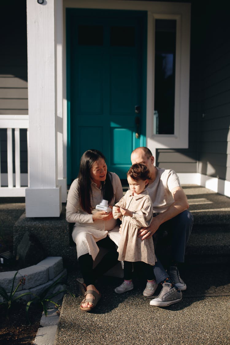 Family Sitting On The Steps To The Porch