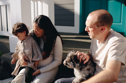 Family Sitting On The Steps To A Porch