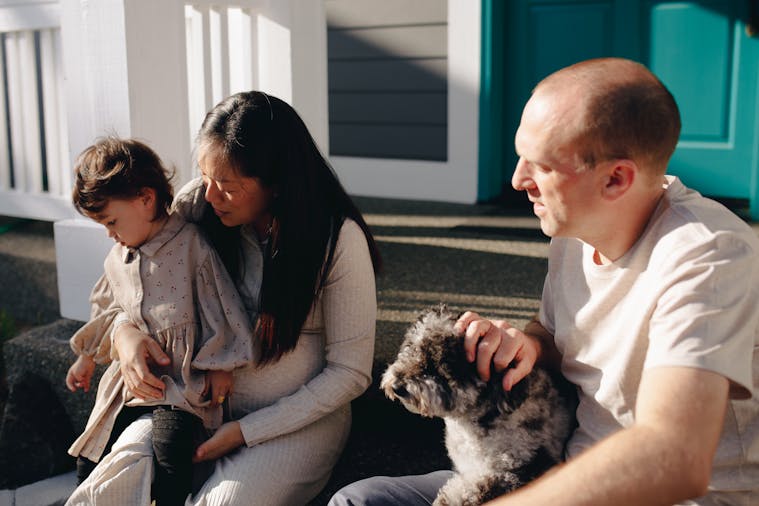 A diverse family enjoying quality time together outdoors with their pet dog.