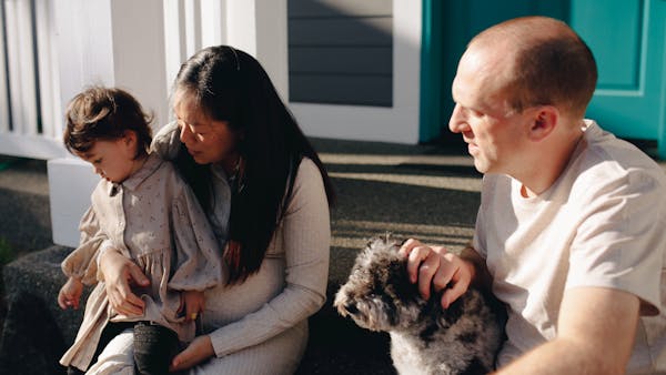 A diverse family enjoying quality time together outdoors with their pet dog.