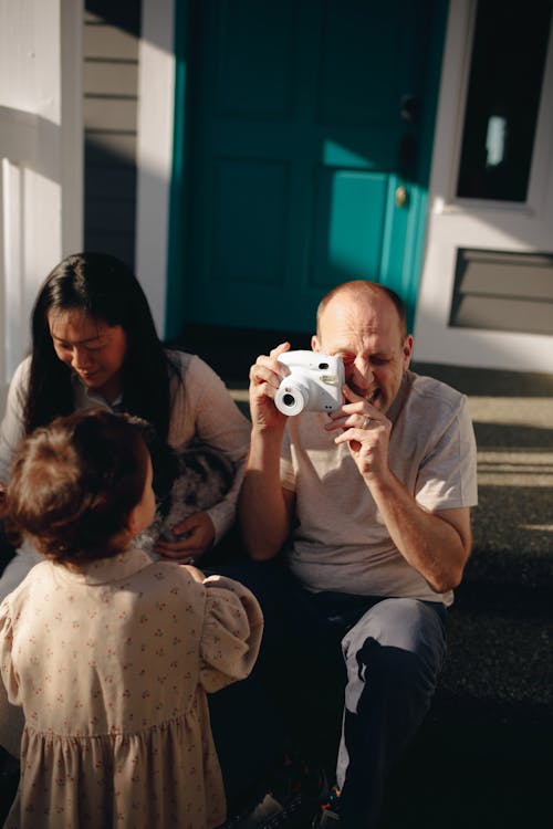 Man Taking A Photo Of His Baby Girl With An Instant Camera
