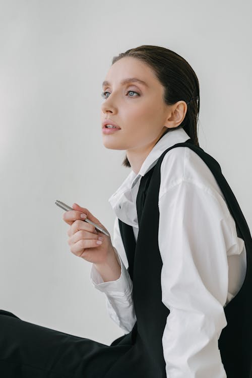 Woman in White Long Sleeve Shirt Holding Pen