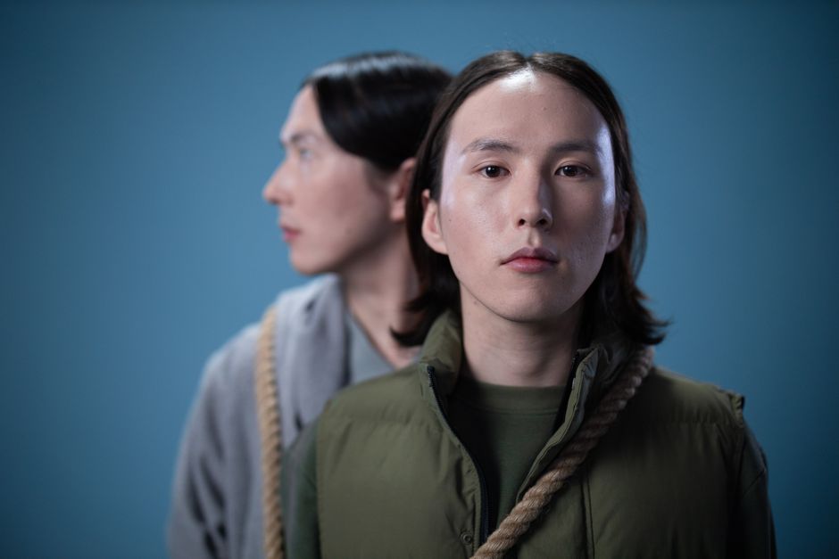 Two people in a conceptual portrait with ropes, captured with selective focus.
