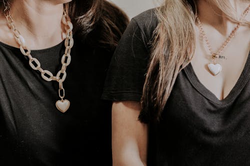 Women wearing black t shirts and chains with pendants