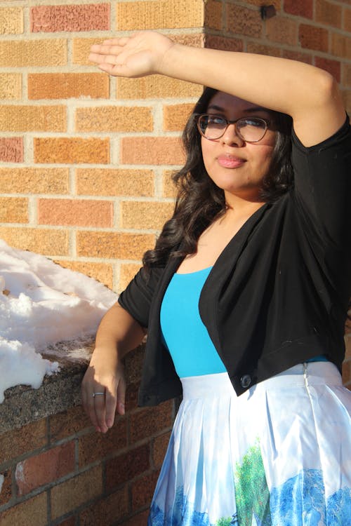 Woman in Black and Blue Sleeveless Dress Wearing Black Framed Eyeglasses