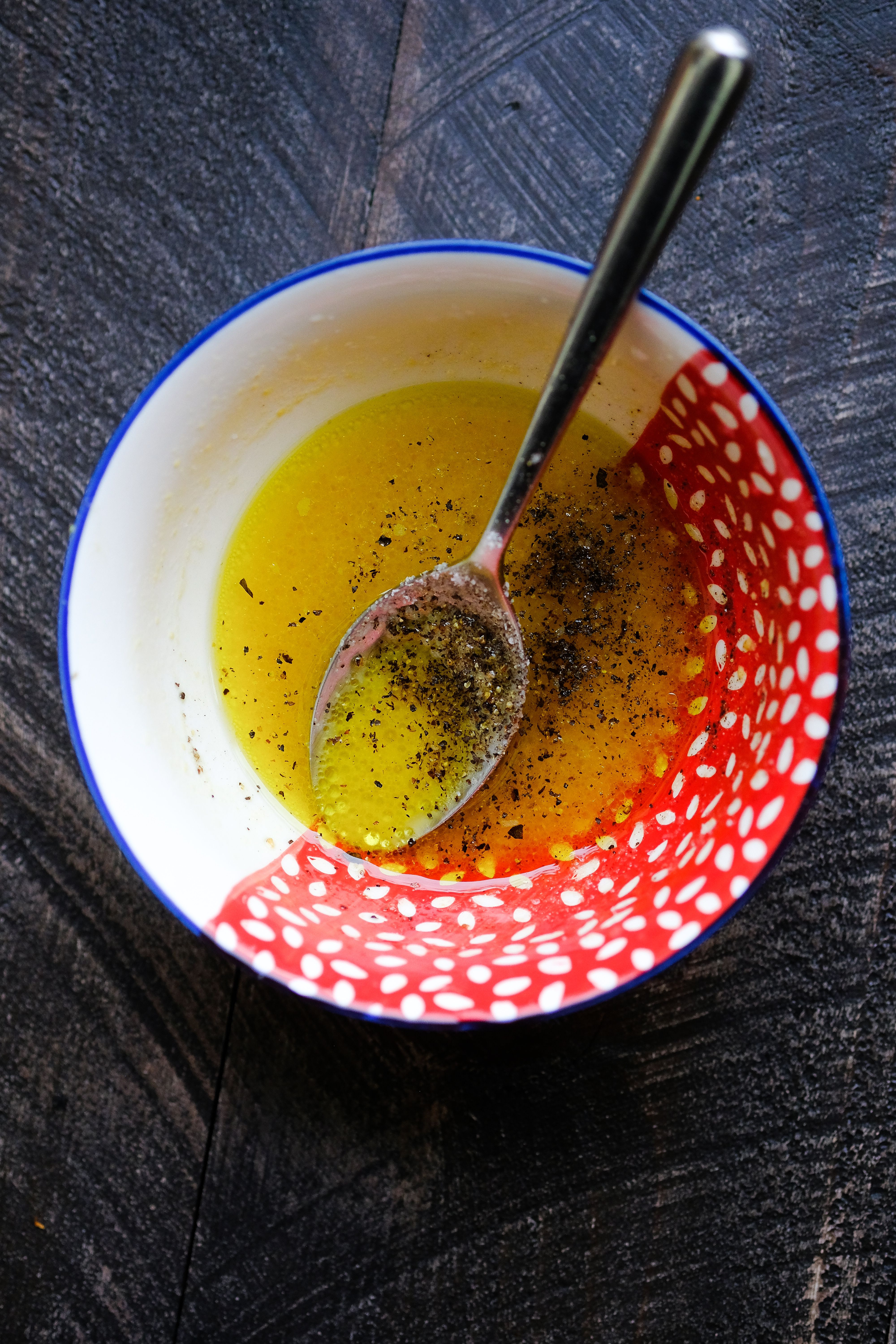 Bowl of golden marinade with herb garnish for chicken seasoning